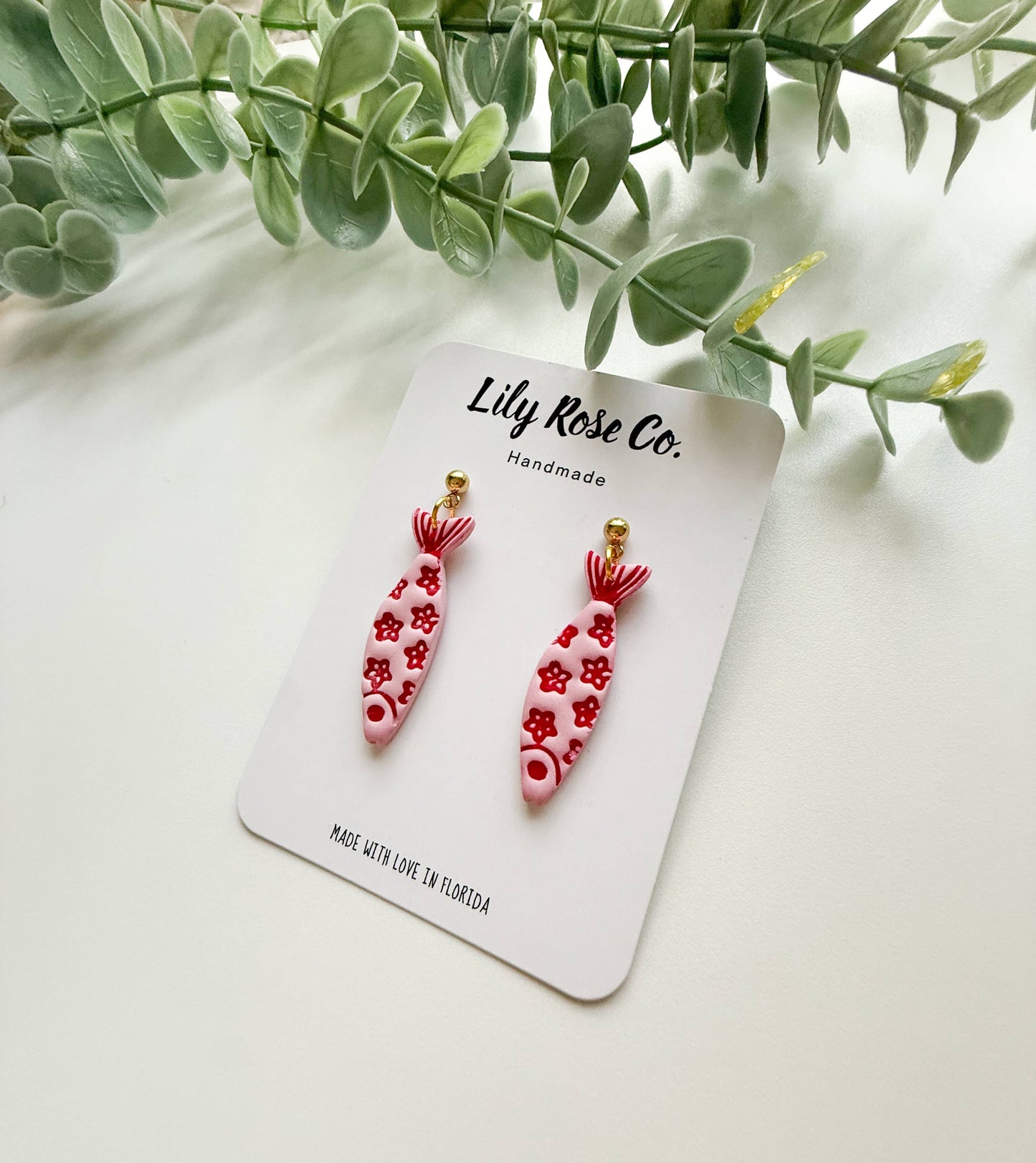 Pink and red floral fish earrings on handmade display card