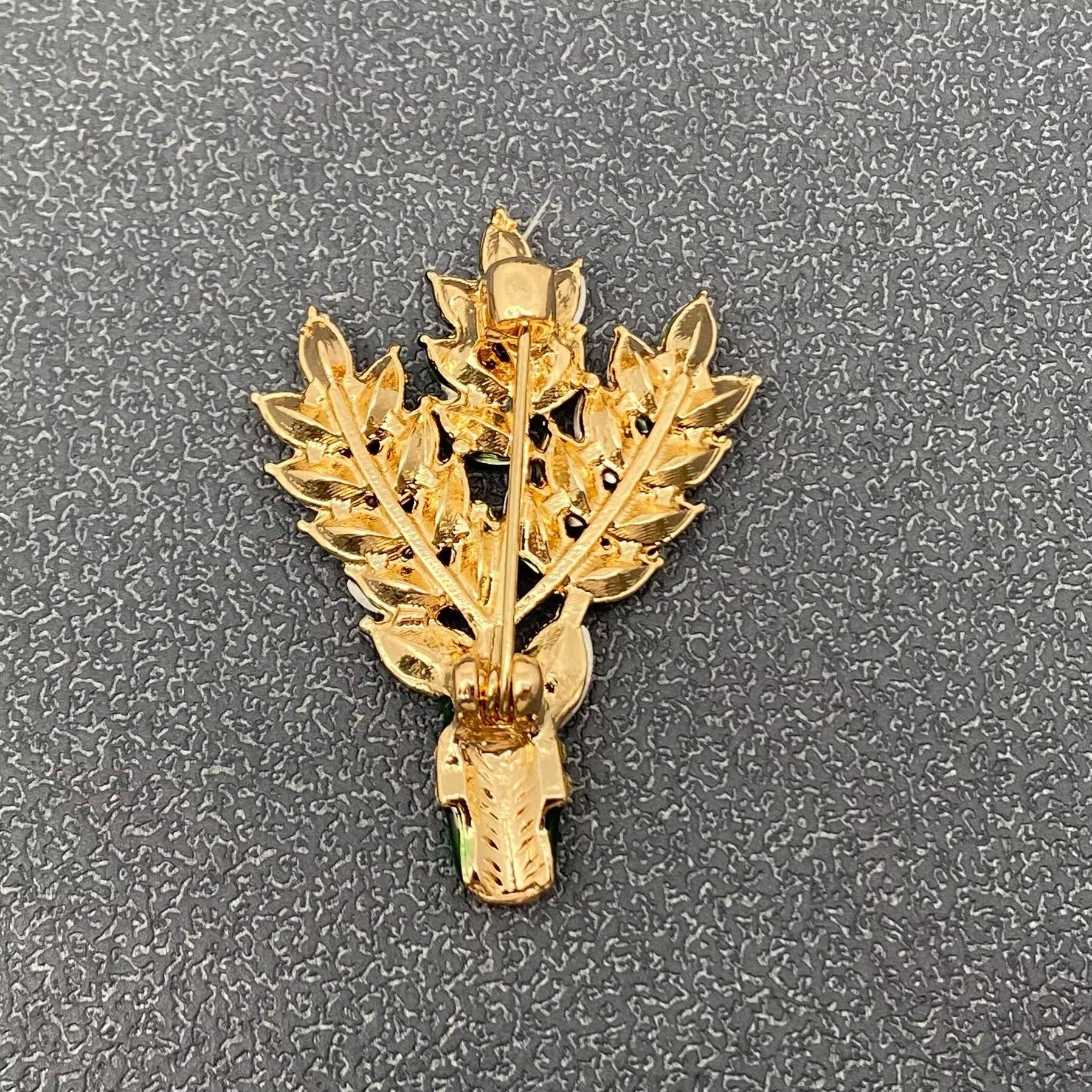 Gold-tone back of lavender floral brooch with pin clasp