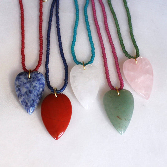 Colorful beaded heart pendant necklaces laid side by side