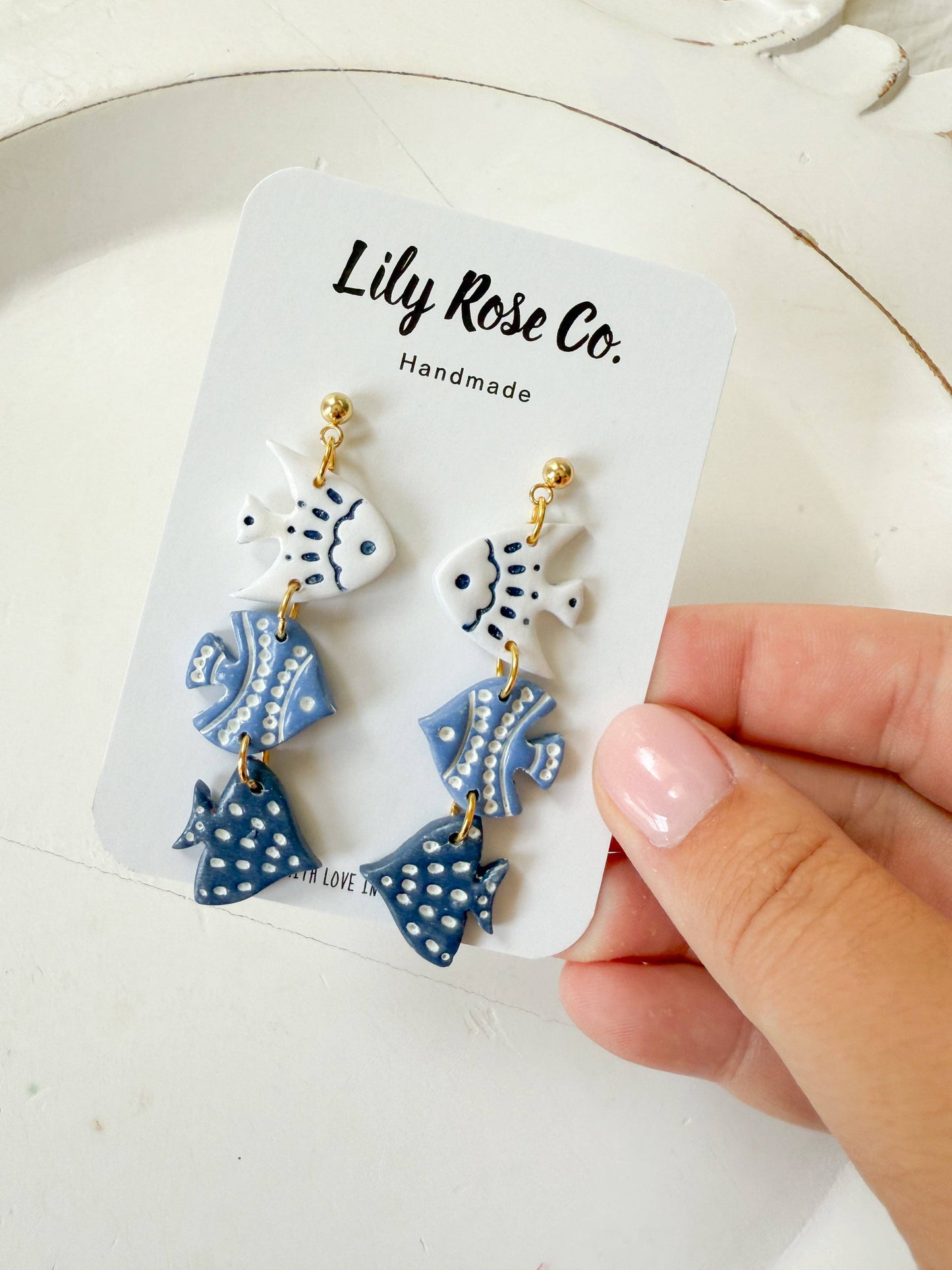 Three-tier blue and white fish earrings on Lily Rose Co display card