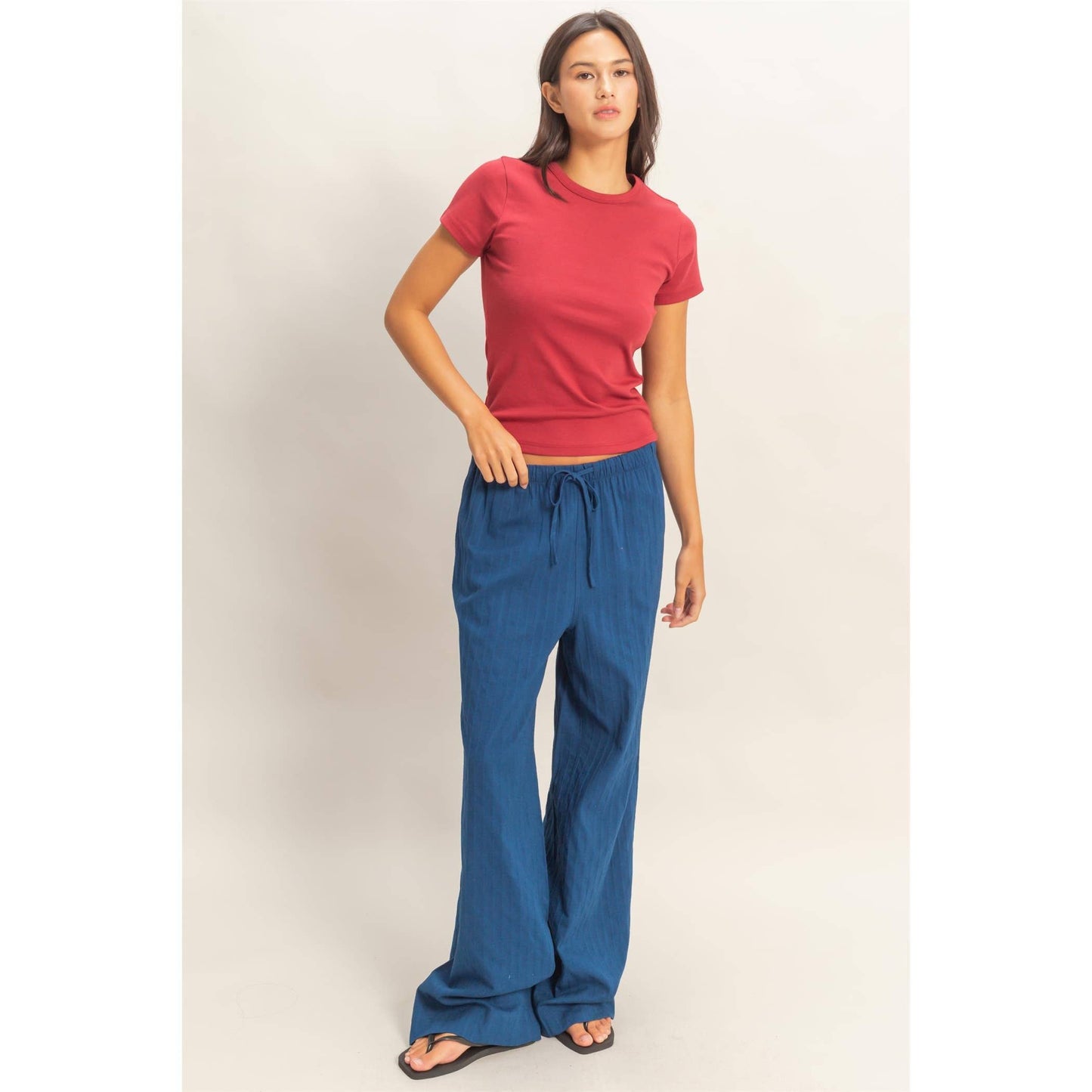 Model wearing rose crew neck short sleeve top with relaxed blue pants