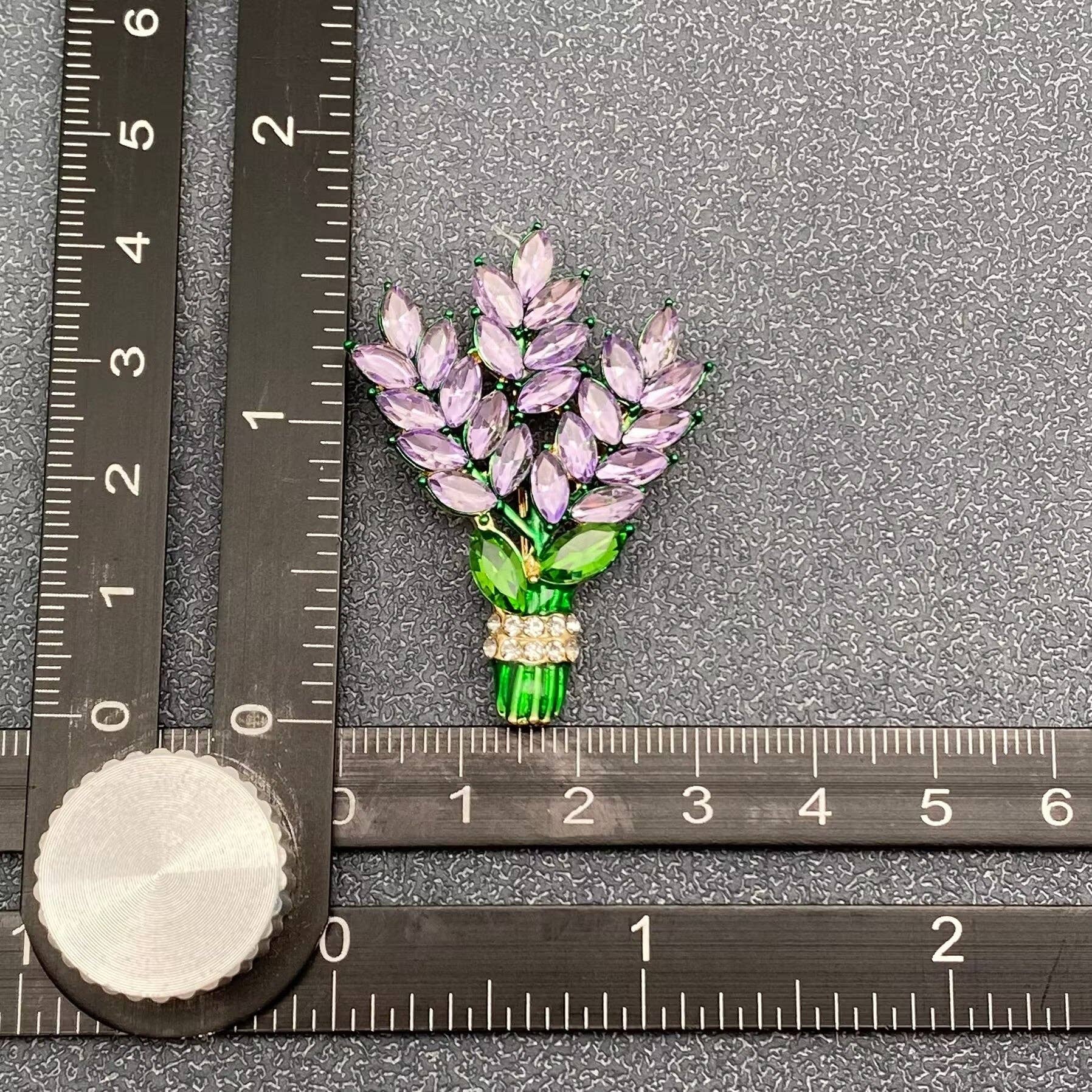 Lavender floral brooch shown beside a ruler for scale