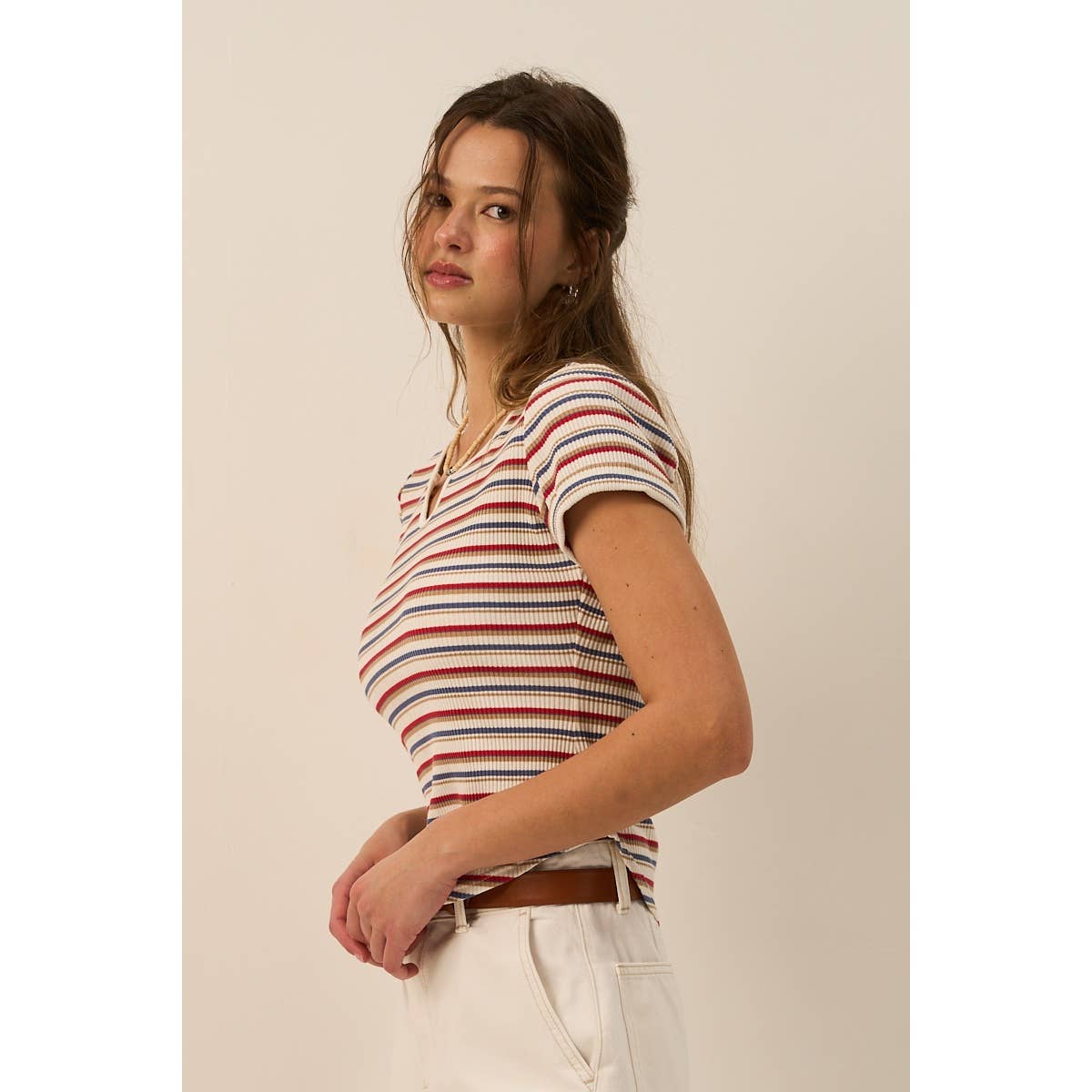 Woman wearing a striped shirt against a plain background