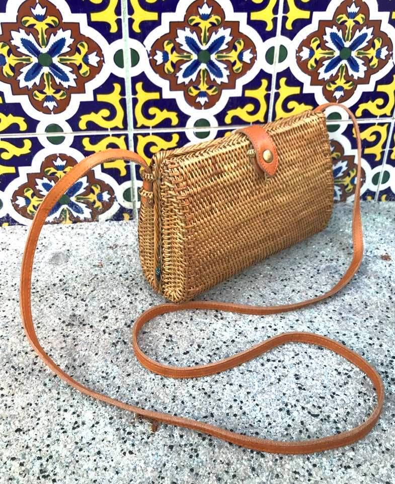 Woven teardrop crossbody bag against patterned tile
