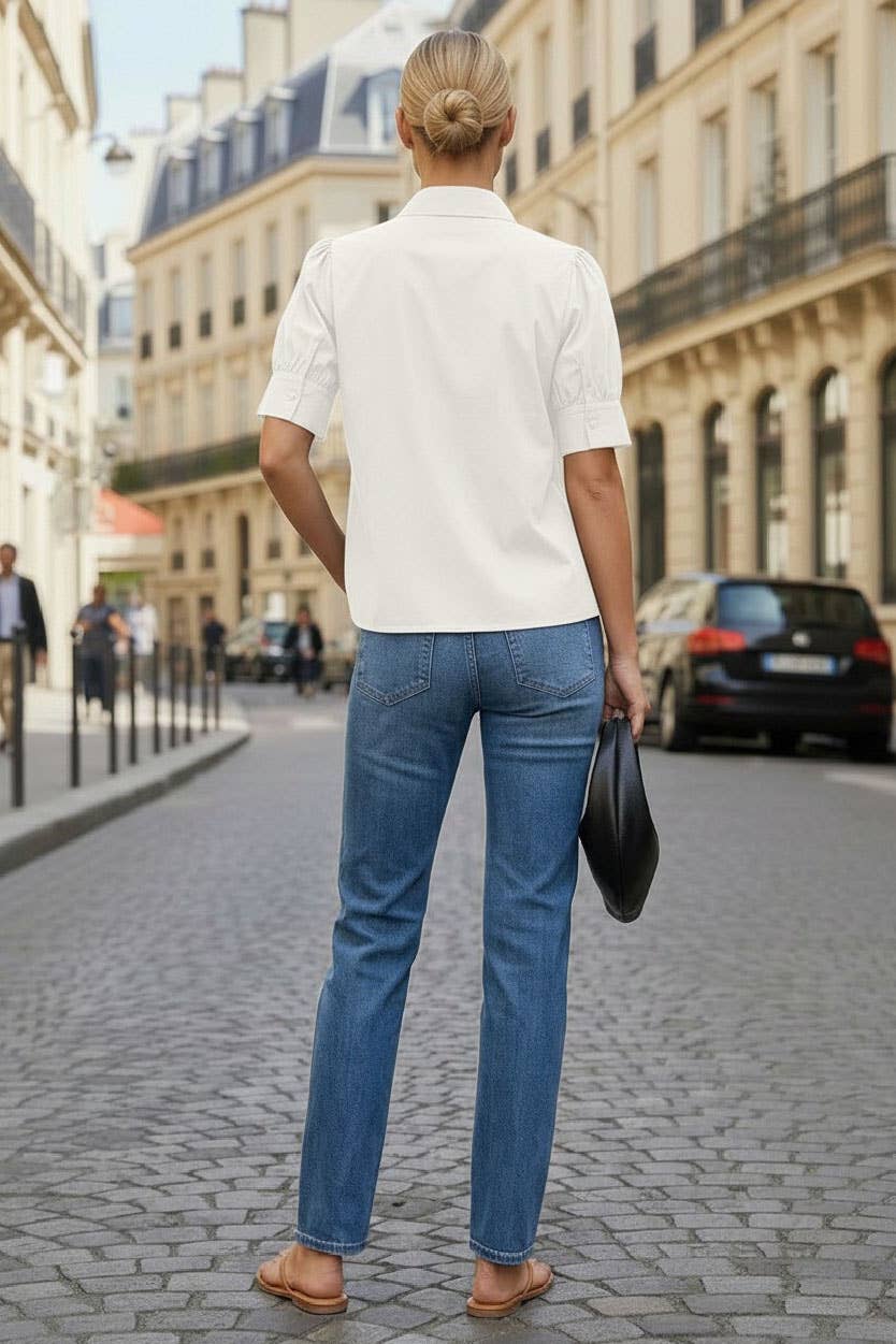 Back view of off white blouse styled with jeans on a city street