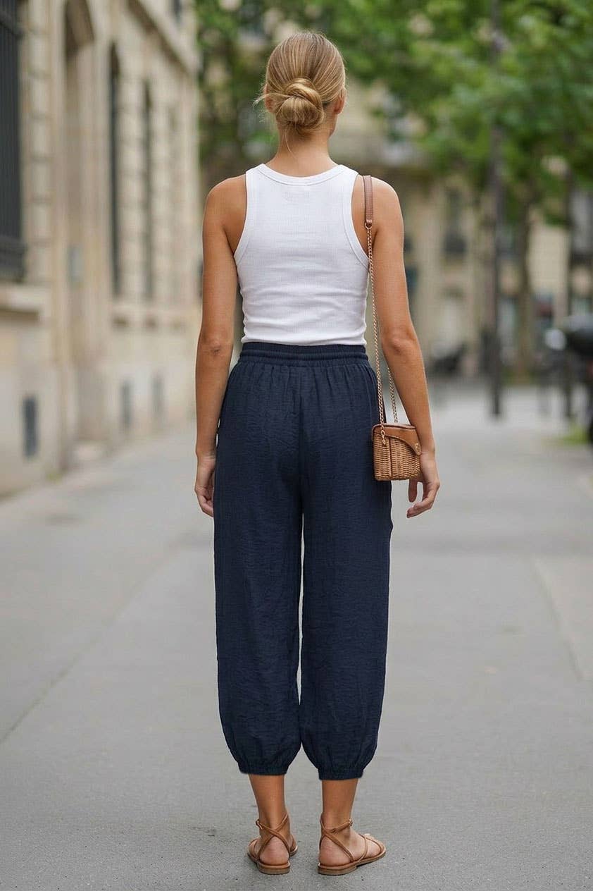 Back view of navy relaxed harem pants styled with a white tank