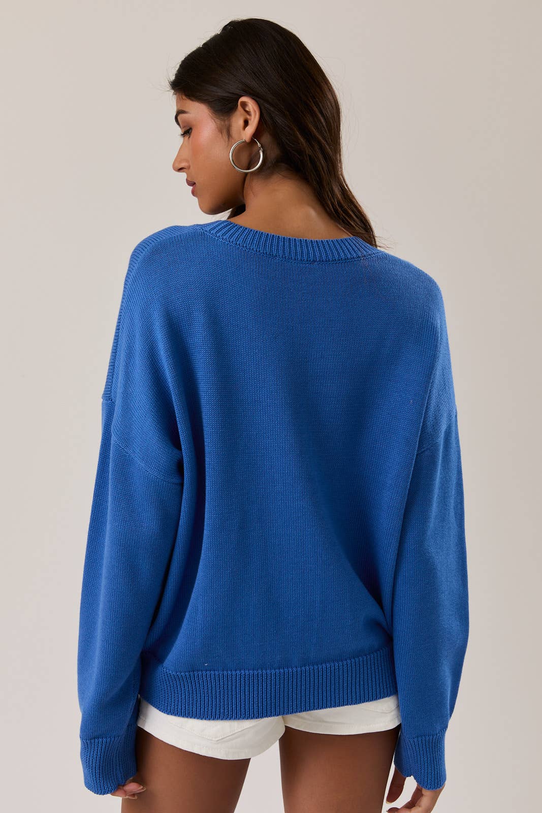 Woman wearing a blue sweater against a neutral background