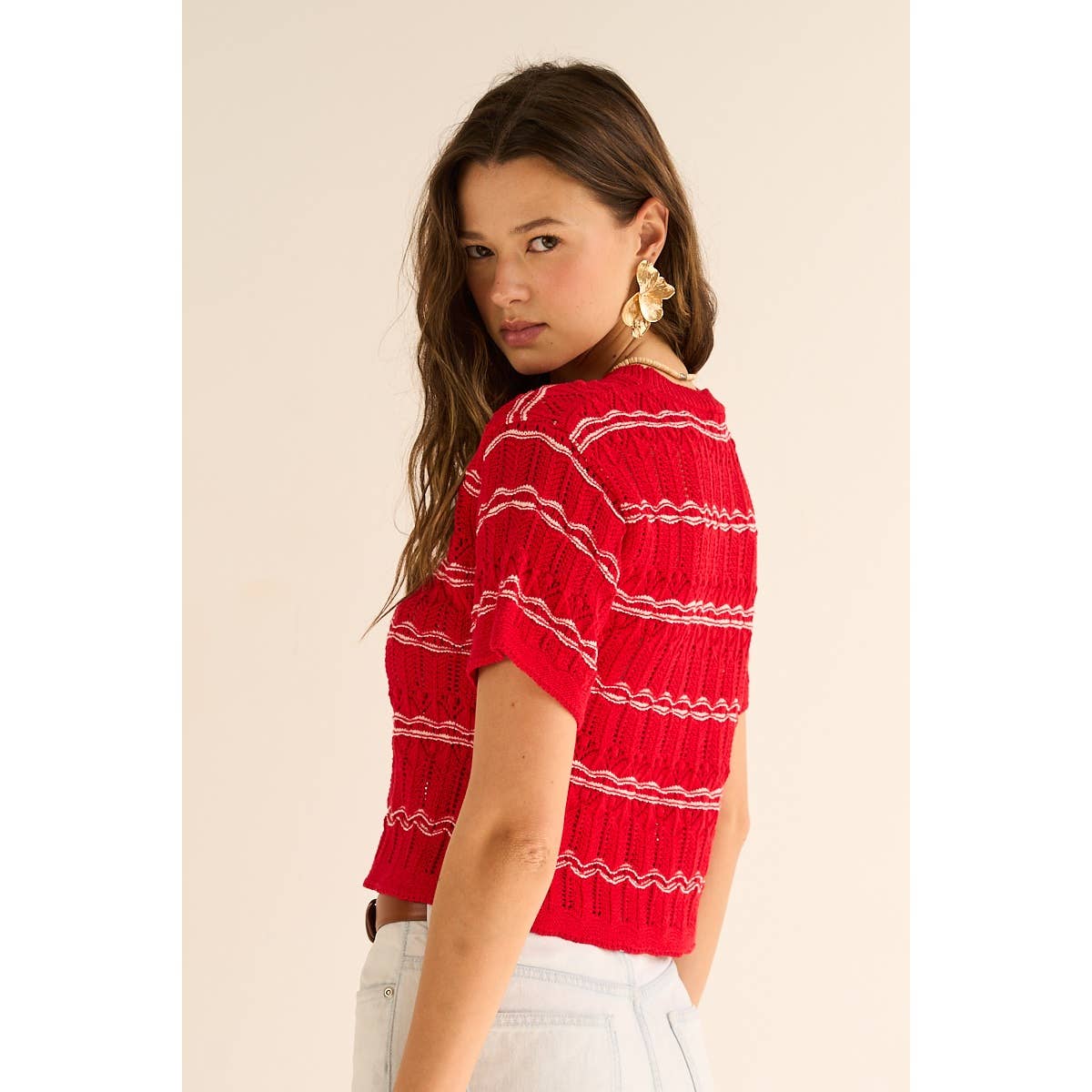 Woman wearing a red striped top against a beige background