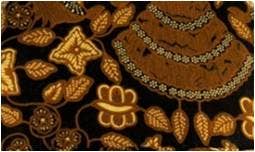 Close-up of a textured fabric with floral patterns in gold on a dark background