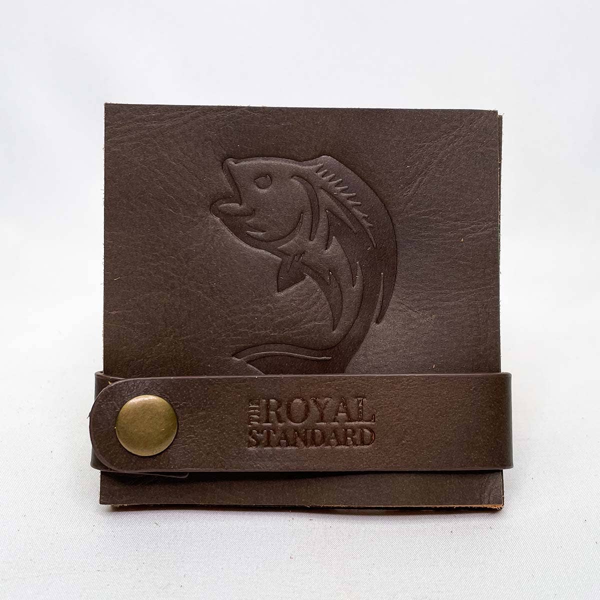 Dark brown embossed fish leather coasters stacked in a snap holder