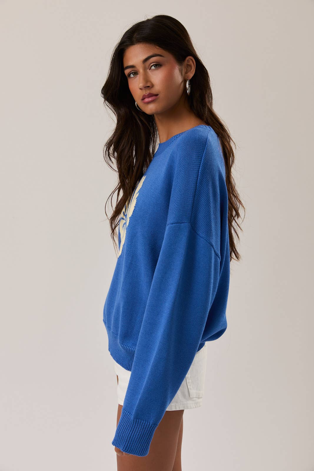 Woman wearing a blue sweater with a plain background