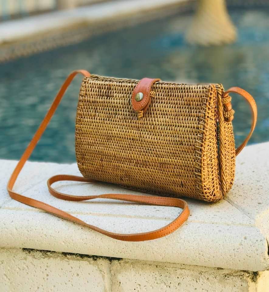 Woven teardrop crossbody bag with leather strap by pool