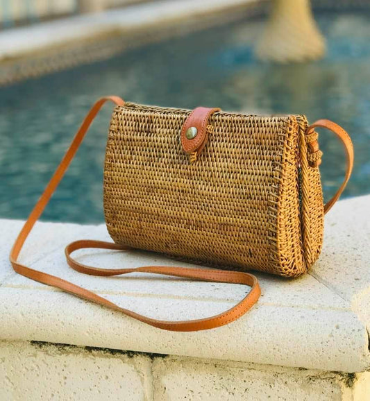 Woven teardrop crossbody bag with leather strap by pool